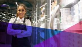 a store clerk smiling in a grocery aisle