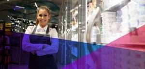 a store clerk smiling in a grocery aisle